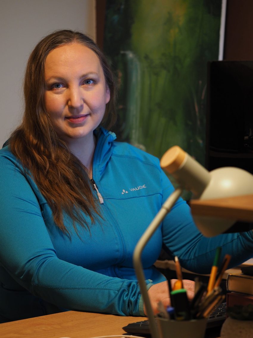 Naine istub, vaatab kaamerasse